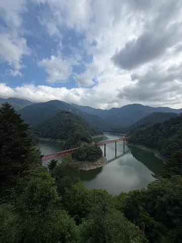 深緑の渓谷を行く赤い鉄橋