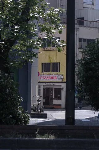 葉陰から覗くピザ屋