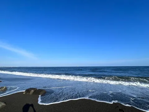 青い空と黒い砂浜のコントラスト