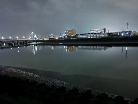 夜の川に灯る街の影