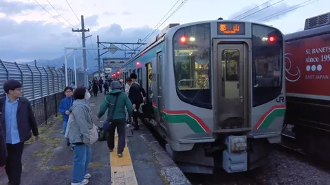 夕暮れの駅と列車の人波