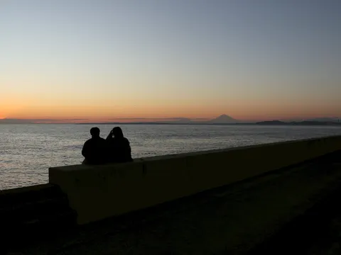 水平線に沈む夕陽と二人のシルエット