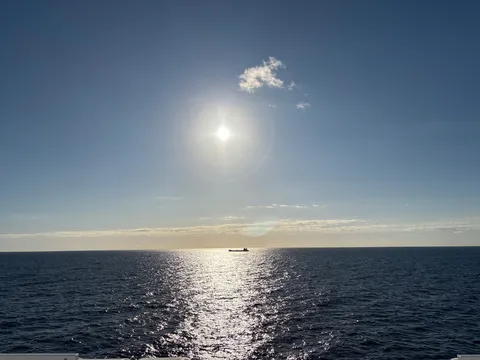 大海原に差し込む太陽と船