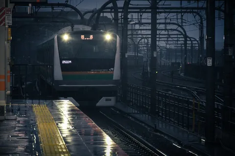 雨夜の駅を照らす列車