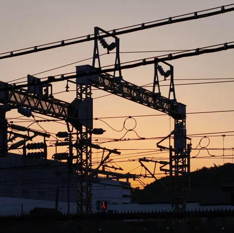 夕暮れの送電線、複雑に絡み合う線