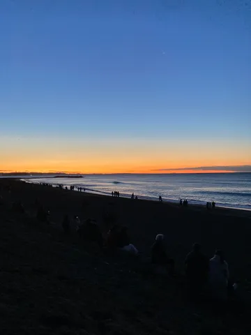 夕暮れに集う人々、静かな海辺のひととき