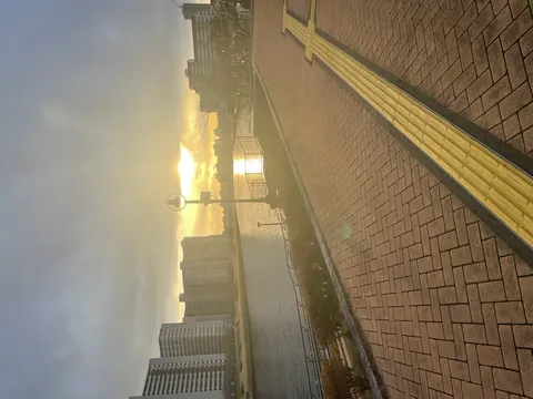 まぶしい夕日と川辺の散歩道
