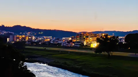 夕暮れに灯る、街と川の静かな時間