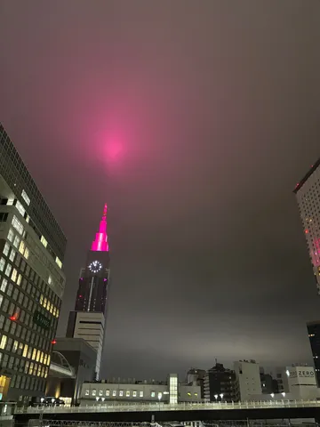 夜空を染めるピンクの光