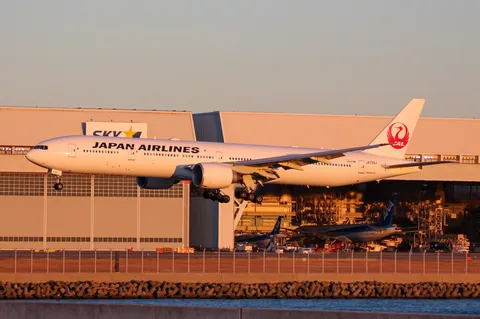 夕暮れの滑走路、着陸態勢のJAL機