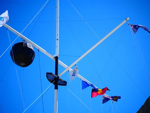 青空と旗が踊るマスト
