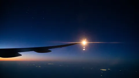 機窓に映る星空と街の灯り