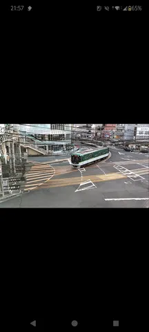 交差点を進む緑の電車