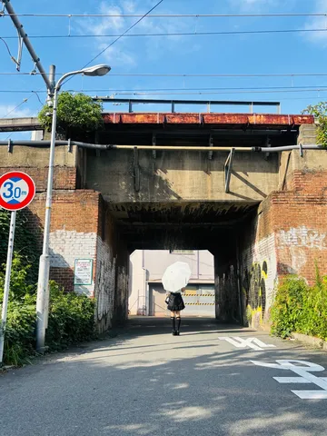 トンネルを抜ける白傘の影