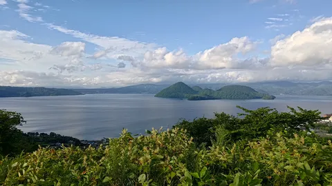 湖畔の緑と雲のコントラスト