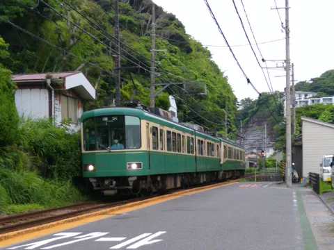緑の車体が映える、山間を走るローカル線