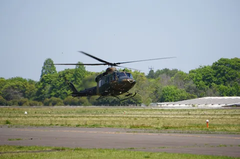 離陸するヘリコプター、青空と緑のコントラスト
