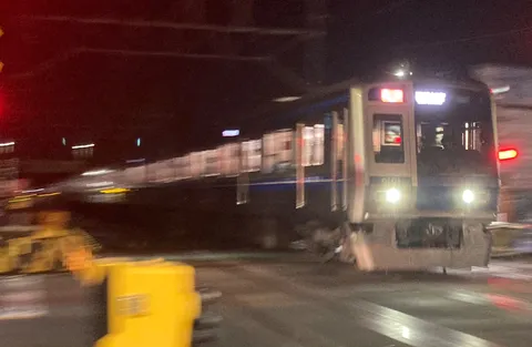 夜の交差点を疾走する列車