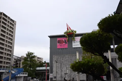 街に飛ぶカエルの看板