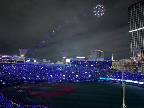 夜空を彩る光の軌跡、スタジアムを包む青い光