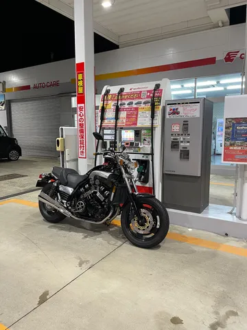 夜の給油所で佇む黒バイク