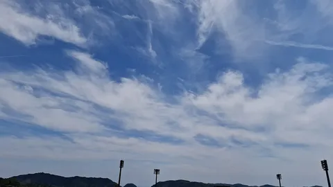 流れる雲と灯台のシルエット