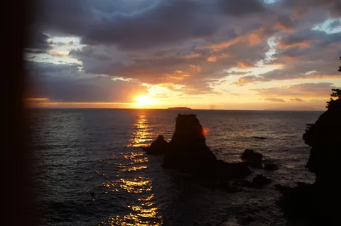 水平線に沈む夕日、波間に光の道
