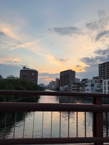 都会の川面に映る、茜色の空
