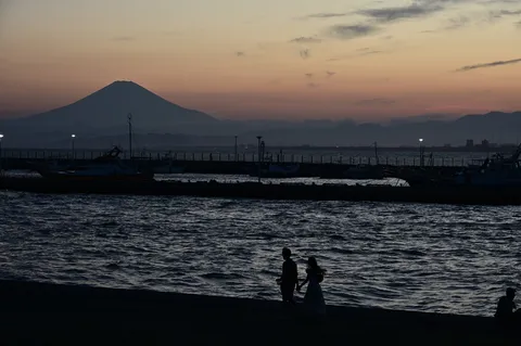 夕凪に歩く二人、富士のシルエット