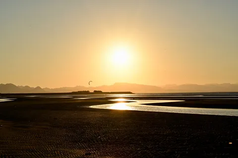 沈む夕陽と砂の光