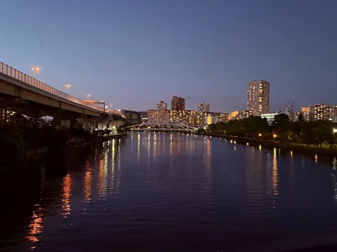 都会の夜景に灯る、水面の光の波紋