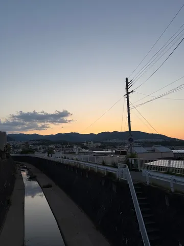 夕暮れの川沿い、静かな街並み
