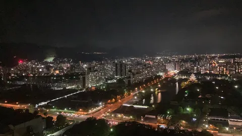 都市の輝きと水辺の古城