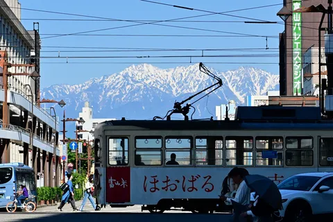 ほおばる電車と雪の山々