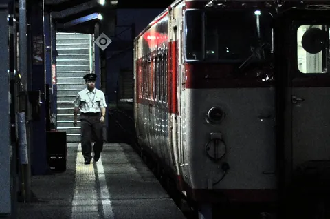 夜の駅で影を歩む列車