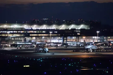 夜空と空港の灯りが交差する瞬間