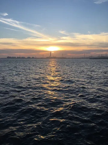 夕暮れの工業地帯と波