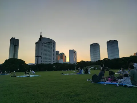 都会の夕暮れ、芝生でピクニック