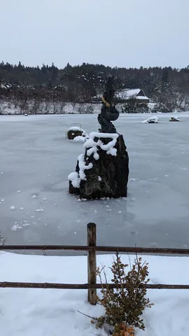 凍った湖に佇む龍の彫刻