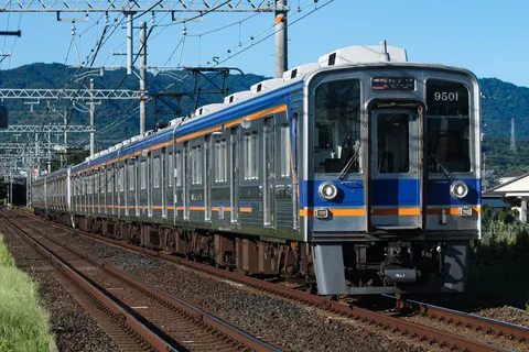 青空の下を走るメタリックな列車