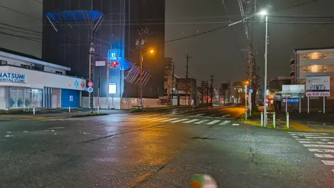 雨夜の交差点に灯る街並み