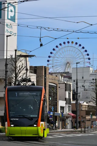 鮮やかな路面電車と青空の観覧車