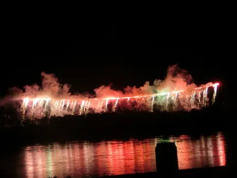 水面に映る、燃えるような夜空の華