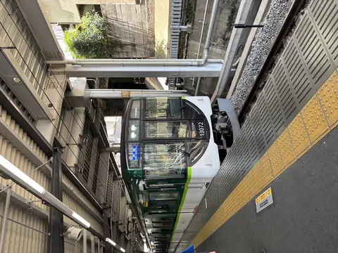 駅のホームに佇む緑の電車