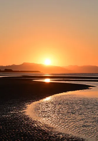 潮だまりにほどける夕日