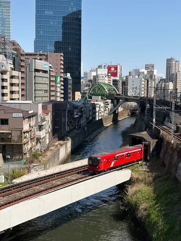 都会の青空と赤い列車