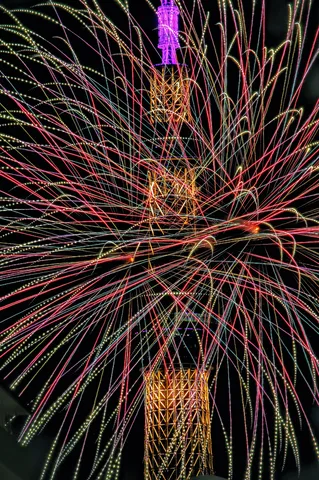 夜空に咲く光の華、タワーを包む
