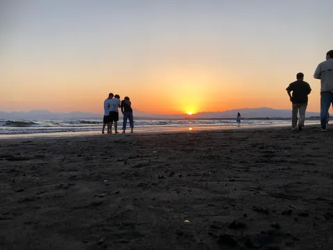 水平線に沈む夕日と砂浜のシルエット