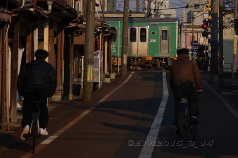 夕暮れの踏切、二人の自転車乗り
