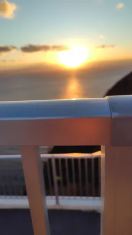 夕暮れの海辺、手すり越しの風景